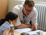 A girl has her lung capacity measured by researcher (2018)